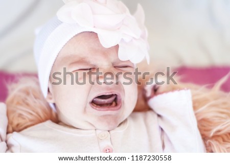 Sweet and adorable Caucasian newborn baby crying. Baby tears, hungry infant concept image. Crying newborn baby. Stomach cramps, baby colic treatment, infant griping pain, uncomfortable infant stock.