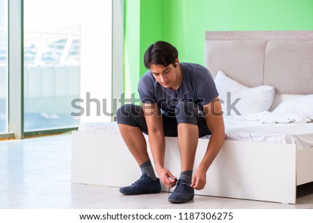 Young handsome man doing morning exercises in the hotel room