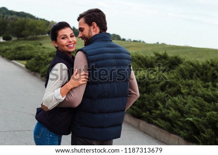 Love and flirt. Young beautiful couple bonding to each other while walking in the park 
