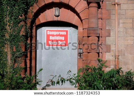 Dangerous building unstable keep out sign on entrance door