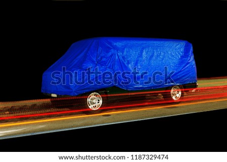 A view of a vintage van car and light trails in a black background