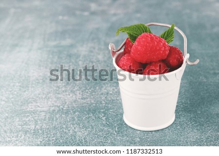 Raspberry in bowl. Raspberry on blue bacground with copy space for text.