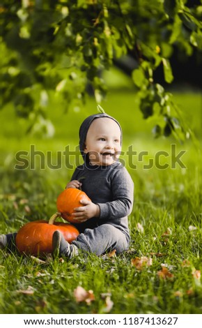 close-up portrait of a beautiful boy in in dragon costume  a  with in a yellow autumn garden park  smiling sunny day celebrates Halloween with pumpkins