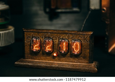 Wooden retro Nixie lamp indicator clock in dark room