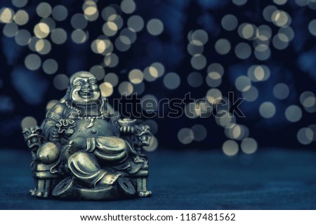 Sitting buddha. Golden statue on blurred background. Vintage toned photo