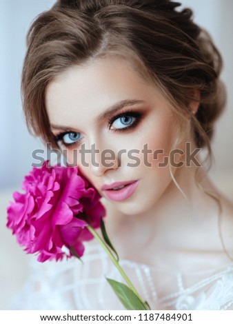 Beautiful model girl , with flowers peony near the face . Cosmetics , beauty, makeup, wedding and cosmetology .
