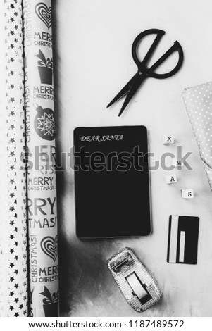 Chritmas online shpping concept, a tablet with text dear santa a beginning of letter for christmas , some wrapping paper, tools to wrap christmas gift and a credit card, business commerce conceptual. 