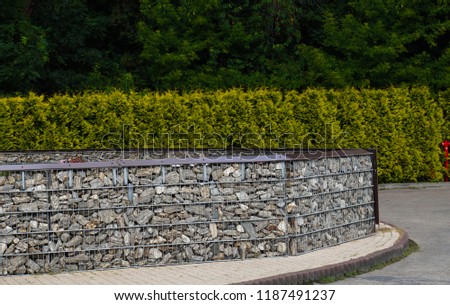 Arrangement of space made with the help of a fence made of stones placed in steel baskets. Gabion.