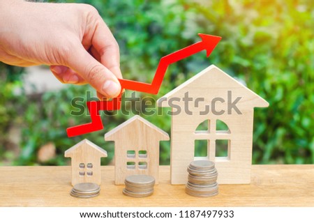 concept of high demand for real estate. population growth. increase in the cost of utilities. property. rise in house prices. wooden houses from small to large with a red arrow up.