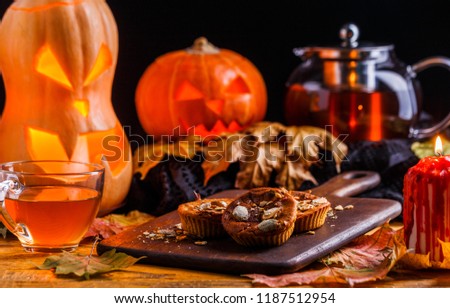 Photo of halloween pumpkins, cakes, cup of tea