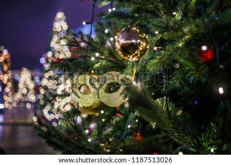 New Year decorated fir-trees on blurred background of burning lights in street at evening
