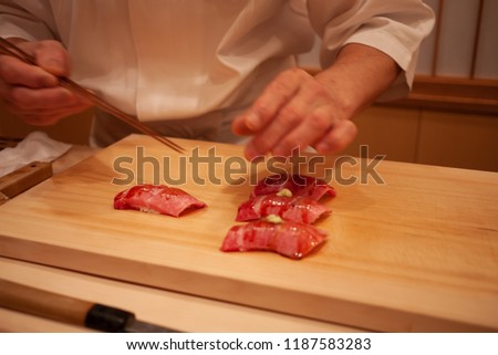 Blurred. Motion. Professional sushi chef carefully add final touch with confident and dedication to his perfect sushi. Precision and Finesse at its best practice to achieve top performance in business