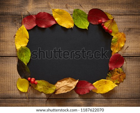 Autumn leaves forming frame on wooden surface. Thanksgiving background.