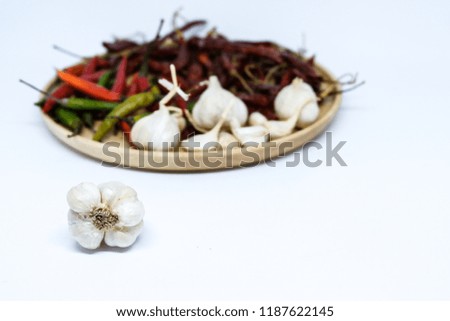 The Blured picture of spices ingredient are hot and spicy herb in Asia. Their are garlic on wooden plate.