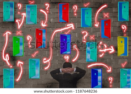 Rear view of businessmen confused with many colorful doors at brick wall, Concepts of decision making and right choice of business and risk management in organization,  Including leadership.