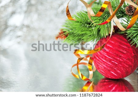 new year tree branch, decoration and ball on silver shining background