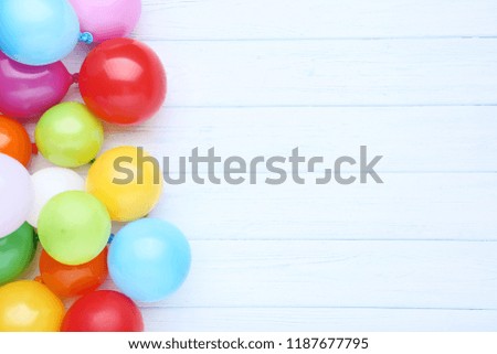 Colorful balloons on white wooden table