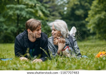 a Portrait of a young couple with a little dog