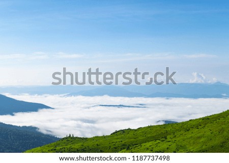 Highlands. Clouds on mountain valley with clear blue sky