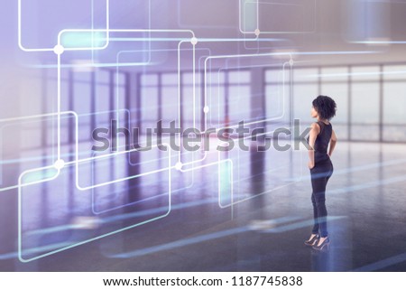 Side view of African American businesswoman standing in an empty office looking at immersive interface hologram in front of her. Hi tech concept. Toned image double exposure copy space