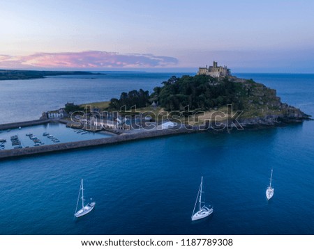 St Michaels Mount Cornwall with the sun rising in the background and yachts in the foreground