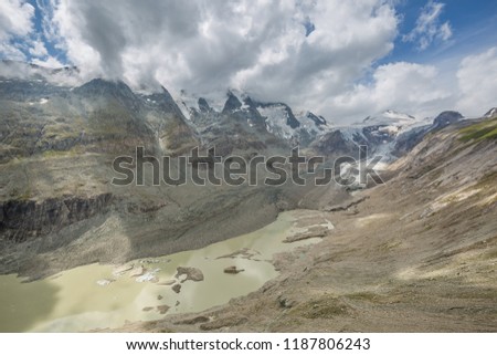 High Alpine lake or dam and meadows near Grossglockner mountain in Austria catching water from Pasterze glacier during the summer melting. Picture taken in Austria in Tirol tauern region.