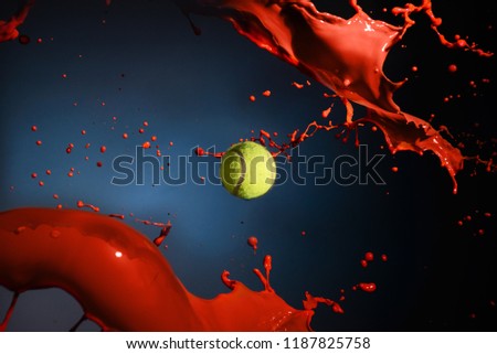 Isolated shot of red paint splash and tennis ball on blue background. Royalty-Free Stock Photo #1187825758