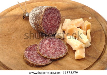 Fresh italian salami sausage with parmesan cheese on a rustically wooden plate
