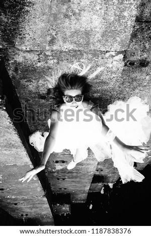 Rock bride. Bride is lying on the stairs. Grunge, retro, hipster style. Young bride in sunglasses, white lace dress, sneakers. Young and beautiful. Old, cracked, stairs. Happiness, casual, lifestyle.