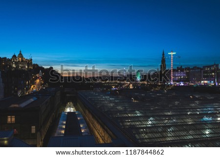 Edinburgh Castle and Christmas Market at twilight with view over train station