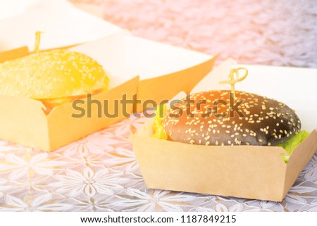 Burger from black bread with sesame seeds and fresh vegetables and Greens, sunny picture