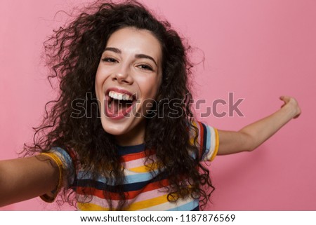 Image of an excited happy cute young woman posing isolated over pink background take a selfie by camera showing copyspace.