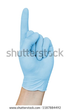 Male hand in blue medical glove showing attention sign with forefinger up, isolated on white background