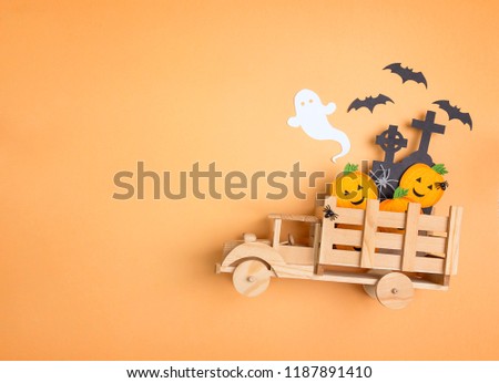 Wooden toy truck with Halloween decorations and copy space. Flat lay festive  concept. 