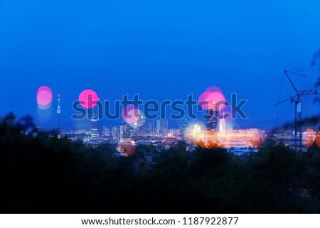 Double exposure of skyscrapers of Vienna Donaucity, overlaid with its defocused lights, on a dusky evening with clear blue sky.