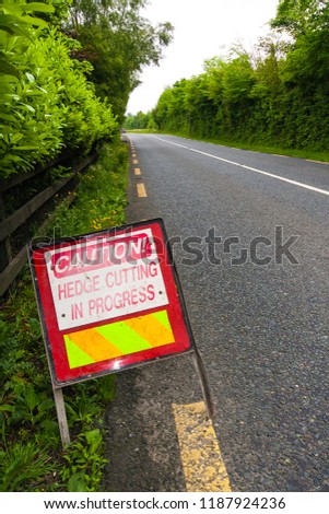 Caution, hedge cutting in progress sign next to an Irish road in Ireland near Dublin