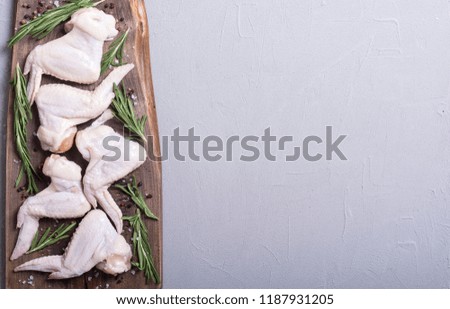 Chicken raw wings with rosemary , garlic , pepper and salt . Ingredient for preparation