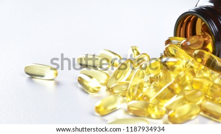Pile fish oil capsules with isolated object and a glass bottle on white background. Omega 3. Vitamin E. Supplementary food. Capsules salmon fish oil gold. Concept Creative.