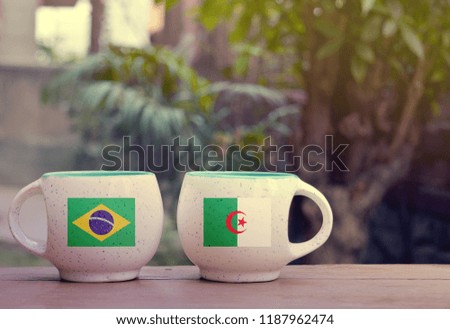 Brazil and Algeria Flag on two tea cups with blurry background