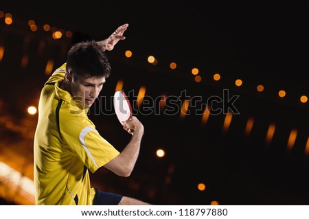 young man tennis-player in play on black background with lights Royalty-Free Stock Photo #118797880