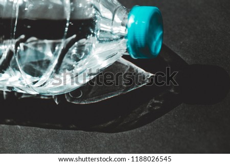 Clear water bottle on black background with light.