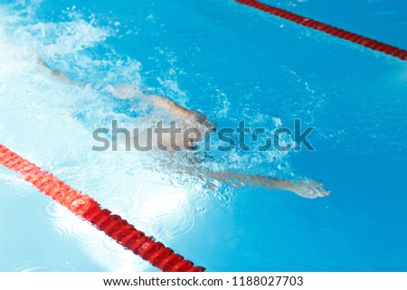 Photo of athlete man swimming under water in swimming pool