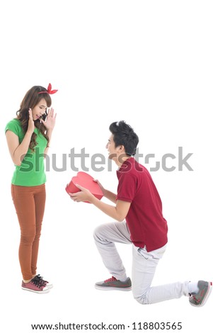 Isolated image of a guy presenting his girlfriend with a heart-shaped giftbox, conceptual shot, good for Valentine'??s Day