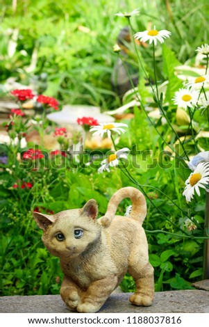 A cat’s figure against the background of beautiful flowers