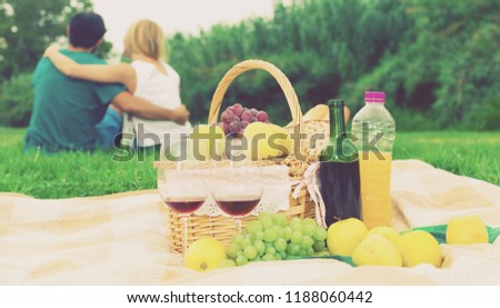 Picture of picnic basket on the grass for couple outdoor.