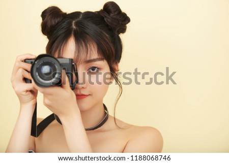 Beautiful creative young woman taking photos with digital camera
