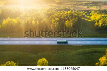 Truck on highway. Truck moving on road in evening. Cargo transportation background. Cargo shipping. Road with truck in sunlight and sun rays. Royalty-Free Stock Photo #1188095047