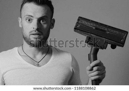 Bearded man with a vacuum cleaner