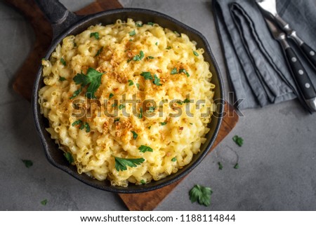 Mac and cheese, american style macaroni pasta with cheesy sauce and crunchy breadcrumbs topping on concrete table, top view Royalty-Free Stock Photo #1188114844