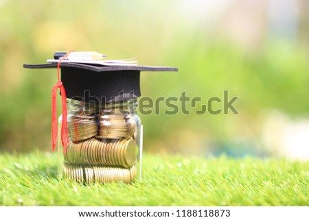 Graduation hat on the glass bottle on natural green background, Saving money for education concept